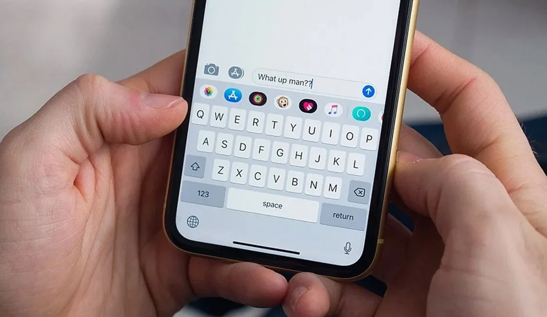 スマートフォンの画面でメッセージを入力している両手